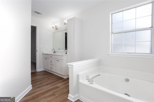 bathroom with a bathtub, vanity, and wood-type flooring