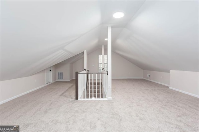 bonus room featuring vaulted ceiling and light carpet