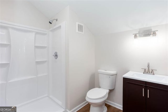 bathroom featuring toilet, vaulted ceiling, walk in shower, wood-type flooring, and vanity