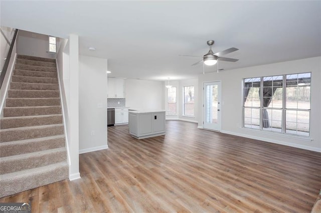 4100 Chanticleer Dr, Kennesaw, GA 30152 - unfurnished living room featuring baseboards, ceiling fan, light wood-style flooring, and stairs