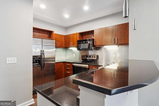 kitchen featuring stainless steel appliances, a kitchen bar, dark stone counters, and kitchen peninsula