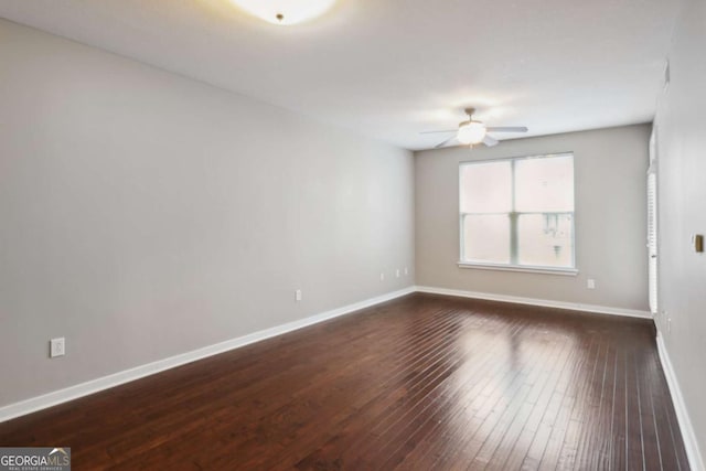 empty room featuring ceiling fan and dark hardwood / wood-style flooring