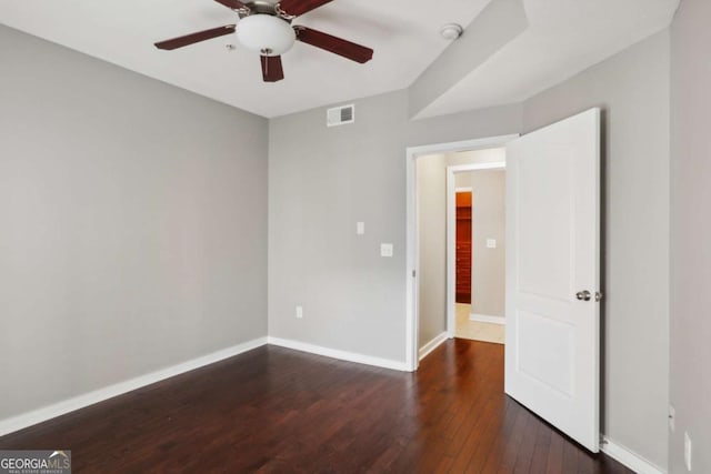 spare room featuring dark hardwood / wood-style flooring and ceiling fan