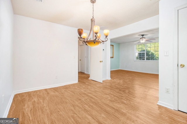 interior space featuring baseboards, ceiling fan with notable chandelier, and light wood-style flooring