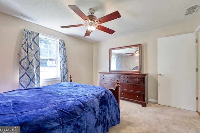 carpeted bedroom with visible vents, a textured ceiling, and ceiling fan