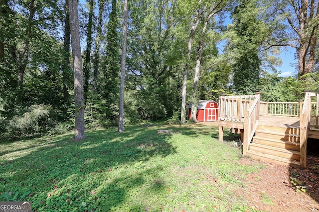 view of yard with a storage unit, an outbuilding, and a deck