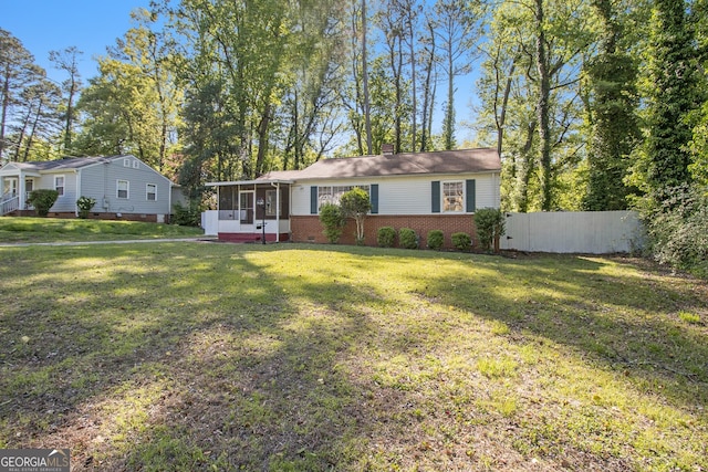 single story home with fence, a chimney, a sunroom, and a front yard