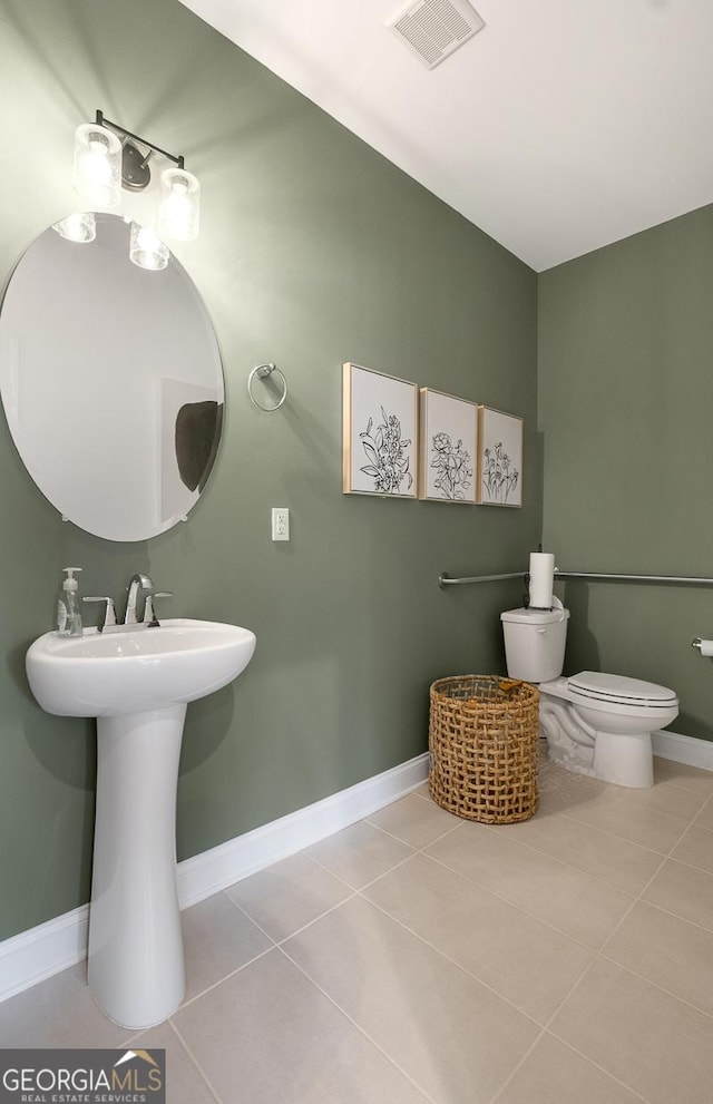 bathroom with toilet and tile patterned floors