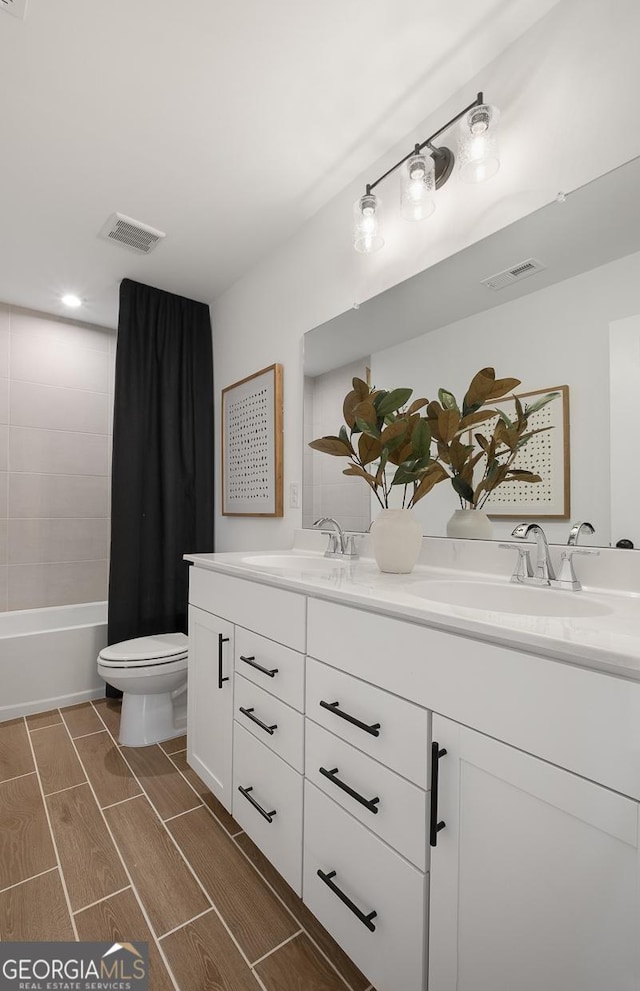 full bathroom featuring toilet, shower / bathtub combination with curtain, and vanity