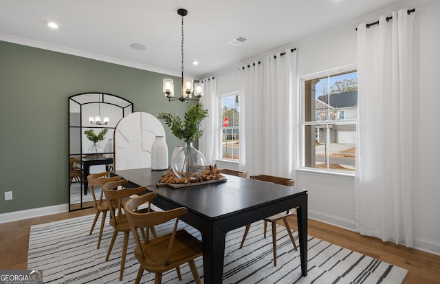 dining room featuring an inviting chandelier, hardwood / wood-style flooring, and crown molding