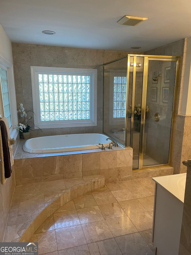 bathroom with vanity, tile patterned flooring, and plus walk in shower