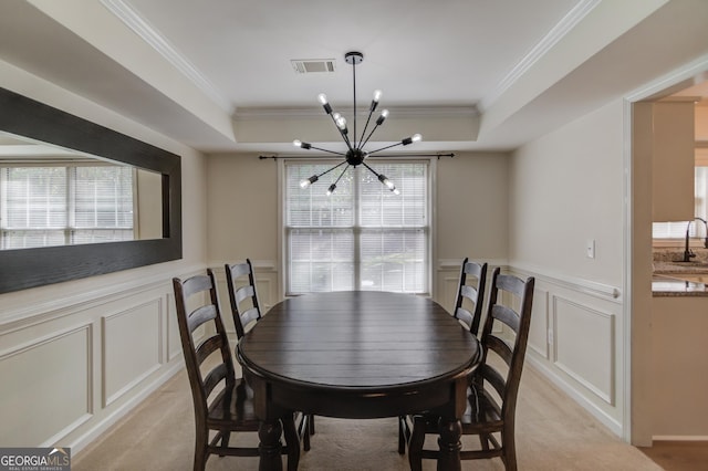 dining area with a chandelier, a tray ceiling, visible vents, and light carpet