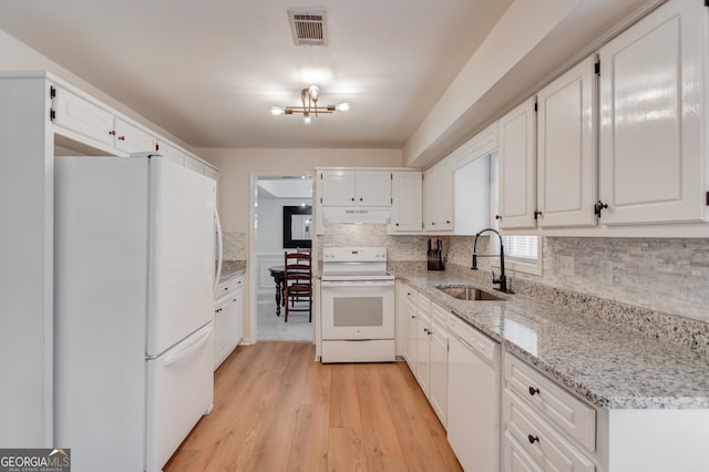 kitchen with visible vents, white cabinets, a sink, white appliances, and under cabinet range hood