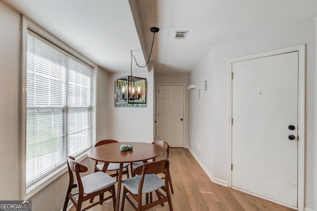 dining room featuring light wood finished floors, plenty of natural light, visible vents, and baseboards