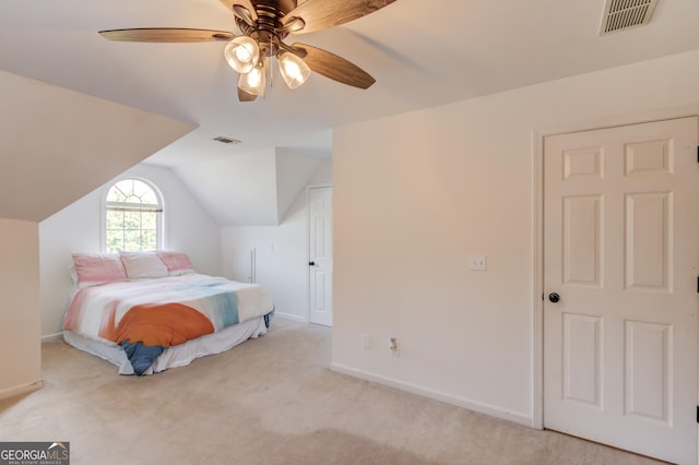 carpeted bedroom featuring a ceiling fan, visible vents, vaulted ceiling, and baseboards