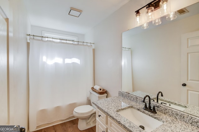 bathroom with toilet, wood finished floors, visible vents, vanity, and shower / bath combination with curtain