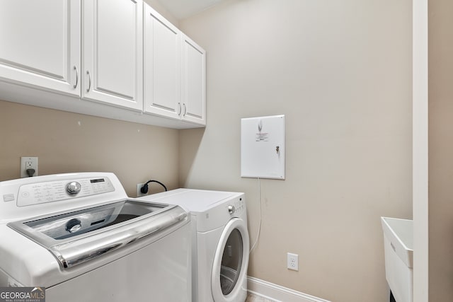 laundry room with washing machine and dryer and cabinets