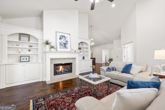 living room with ceiling fan, dark hardwood / wood-style floors, a fireplace, and built in shelves