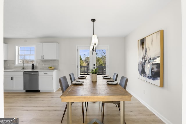 dining space featuring light hardwood / wood-style floors, french doors, and sink