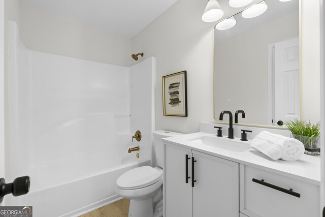 full bathroom with toilet, wood-type flooring, vanity, and bathing tub / shower combination