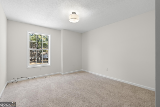 carpeted spare room featuring a textured ceiling