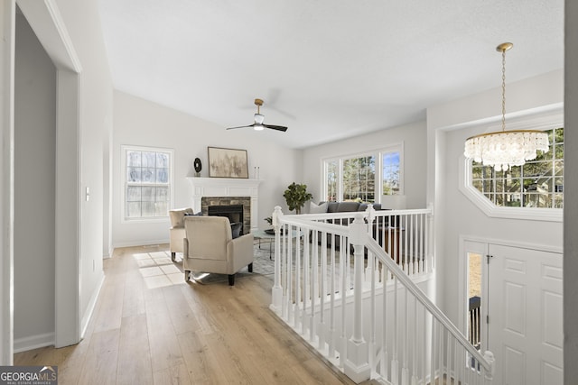 interior space with light hardwood / wood-style flooring, an inviting chandelier, and lofted ceiling