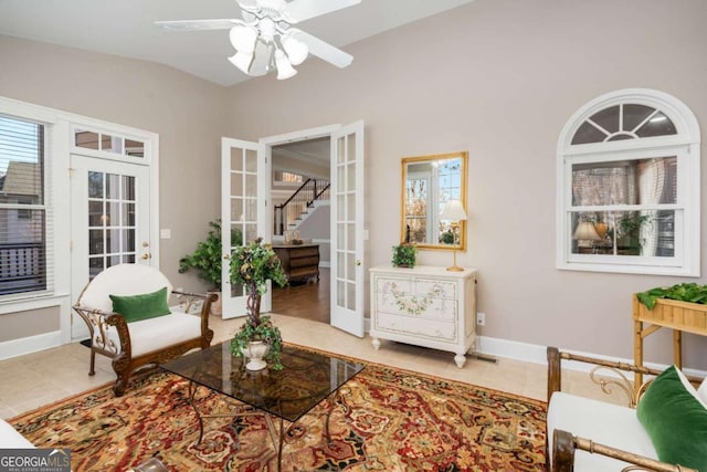 living area featuring ceiling fan, french doors, tile patterned flooring, and lofted ceiling