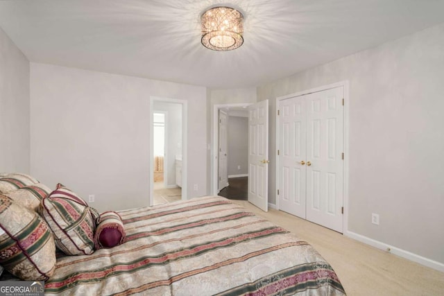 bedroom featuring ensuite bath and light colored carpet