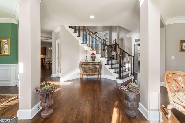 entryway with ornamental molding and hardwood / wood-style flooring