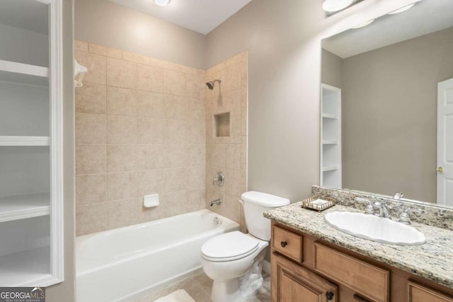 full bathroom with vanity, tiled shower / bath combo, and toilet