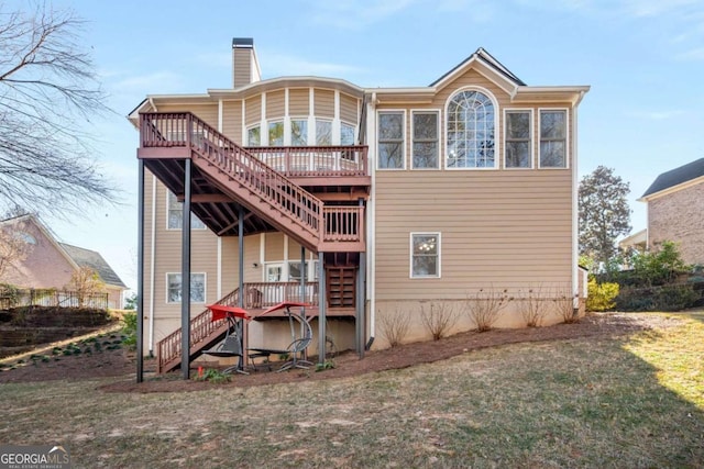 back of property with a wooden deck and a lawn