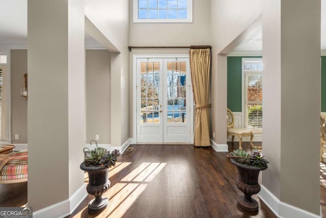 entrance foyer featuring ornamental molding, dark wood-type flooring, french doors, and plenty of natural light