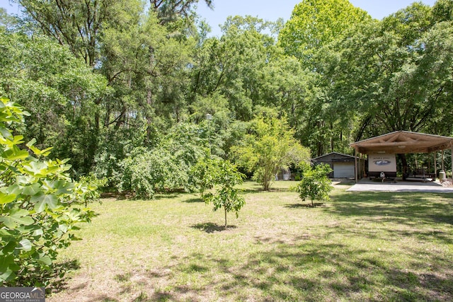 view of yard featuring a garage and an outbuilding