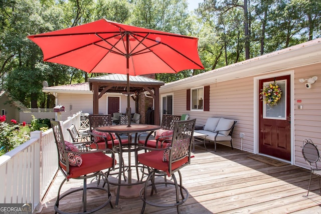 wooden terrace featuring a gazebo and an outdoor living space