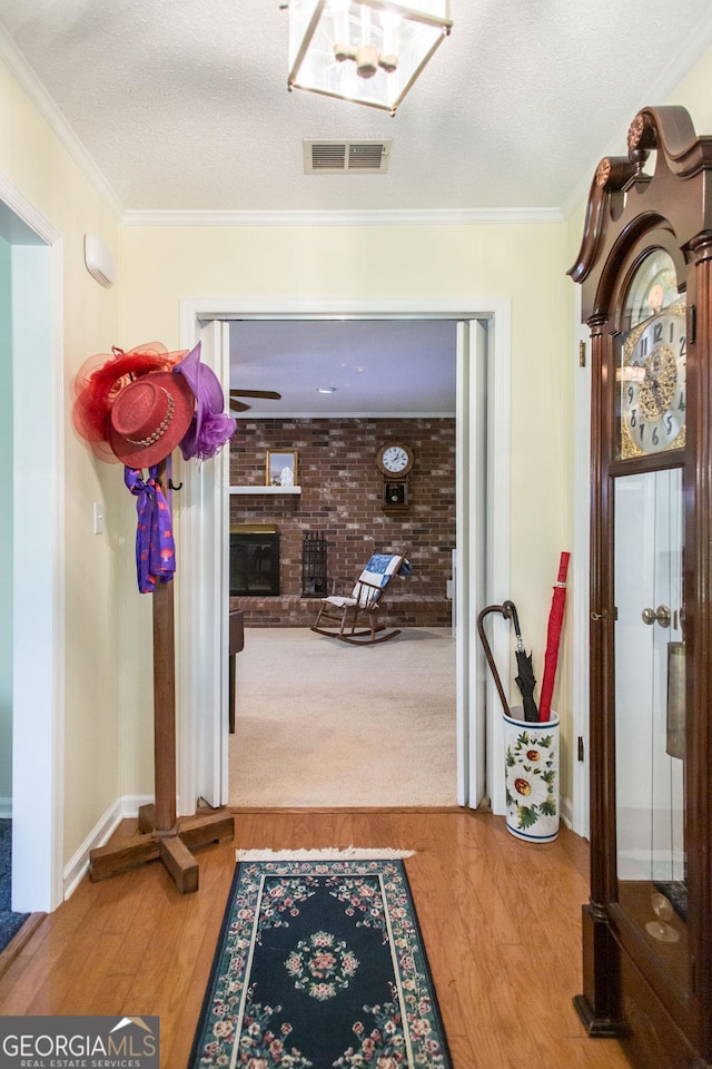 interior space with wood-type flooring, a textured ceiling, and crown molding