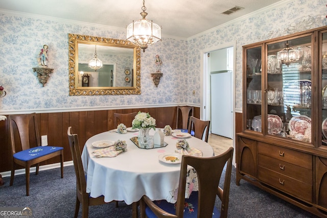 dining space featuring carpet floors, ornamental molding, and a chandelier