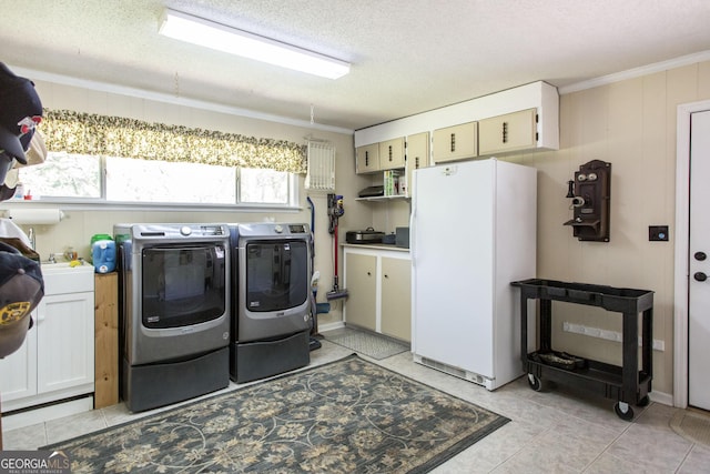 laundry room featuring a textured ceiling, wooden walls, ornamental molding, and washing machine and dryer