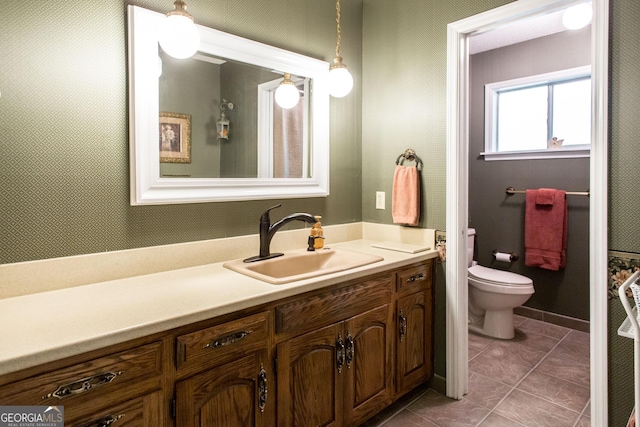 bathroom with toilet, tile patterned flooring, and vanity