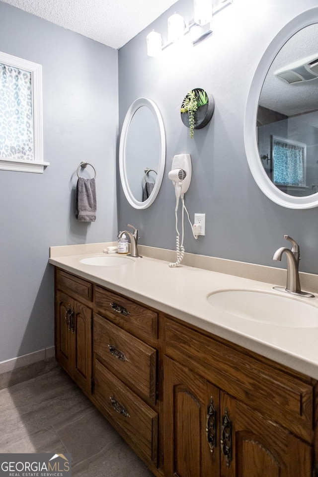 bathroom with a textured ceiling and vanity