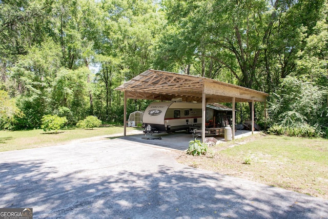 view of parking featuring a yard and a carport