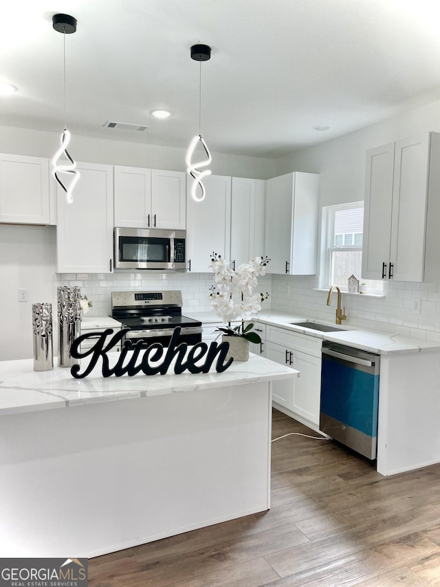 kitchen with white cabinets and appliances with stainless steel finishes