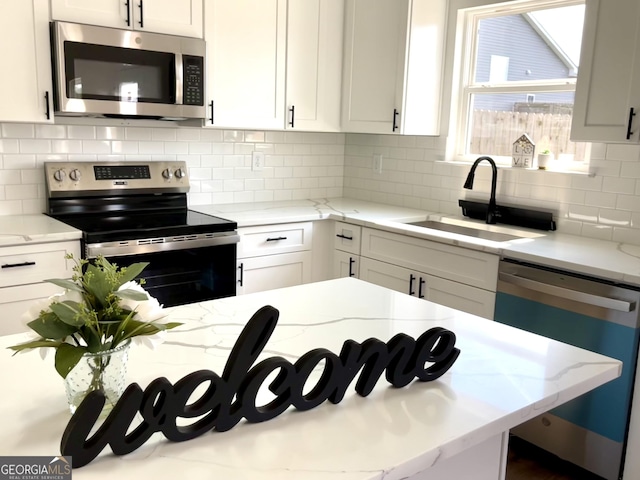 kitchen with sink, stainless steel appliances, and white cabinetry