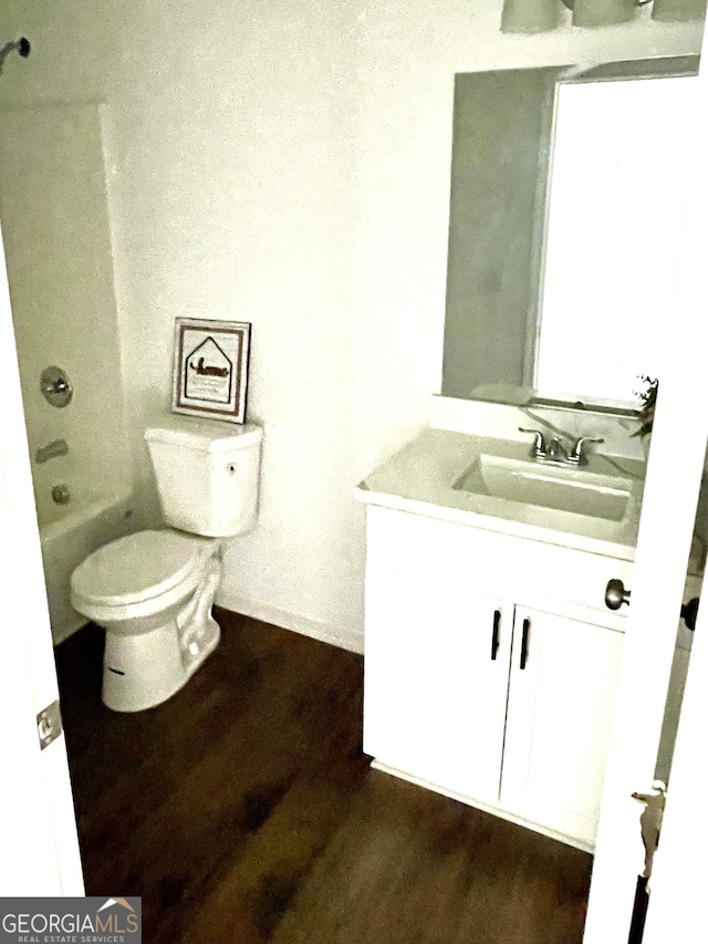 bathroom with toilet, wood-type flooring, and vanity