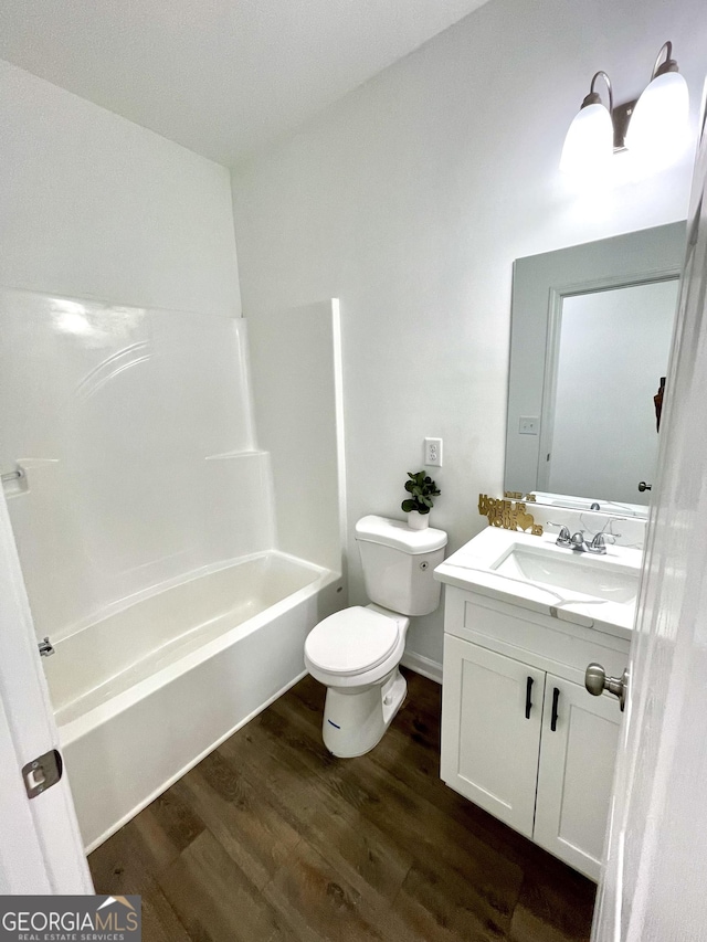 full bathroom with toilet, hardwood / wood-style flooring, bathing tub / shower combination, and vanity