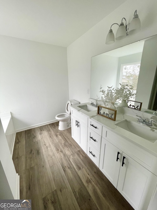 bathroom with toilet, vanity, and hardwood / wood-style floors