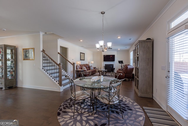 dining room with a chandelier, ornamental molding, and dark wood-type flooring