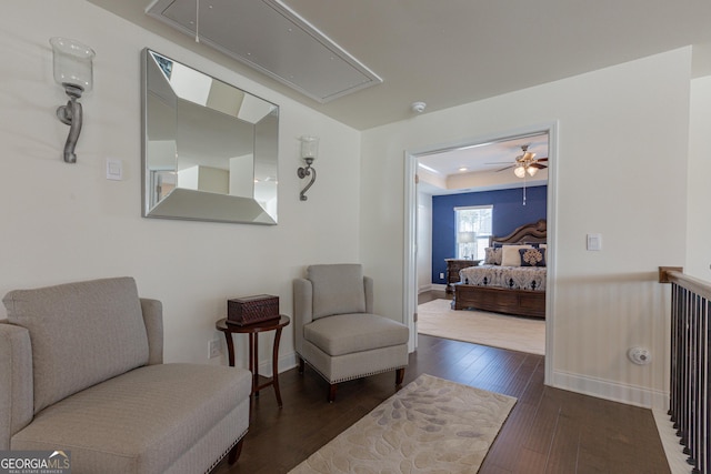 living area with ceiling fan and dark hardwood / wood-style floors