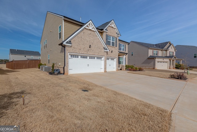 view of front of property with central air condition unit, a front yard, and a garage