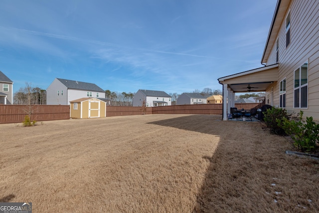 view of yard featuring ceiling fan and a storage unit