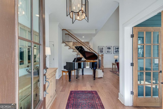 foyer entrance featuring light hardwood / wood-style floors and a chandelier